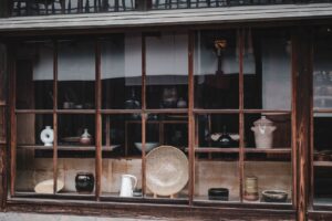 Vintage pottery displayed in a traditional Kurashiki shop window, showcasing Japanese craftsmanship.
